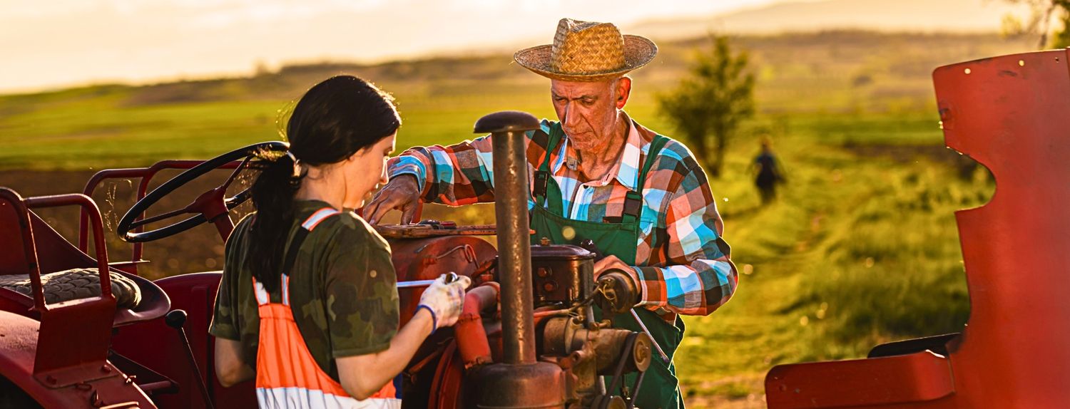 Agricultores con tractor utilizando accesorios para tractor en labores del campo